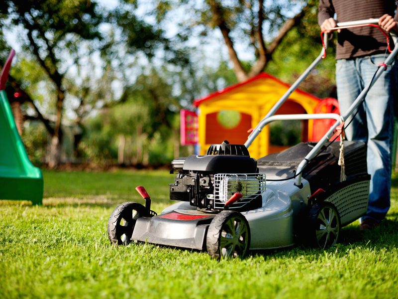 Mower cutting a bright green residential lawn