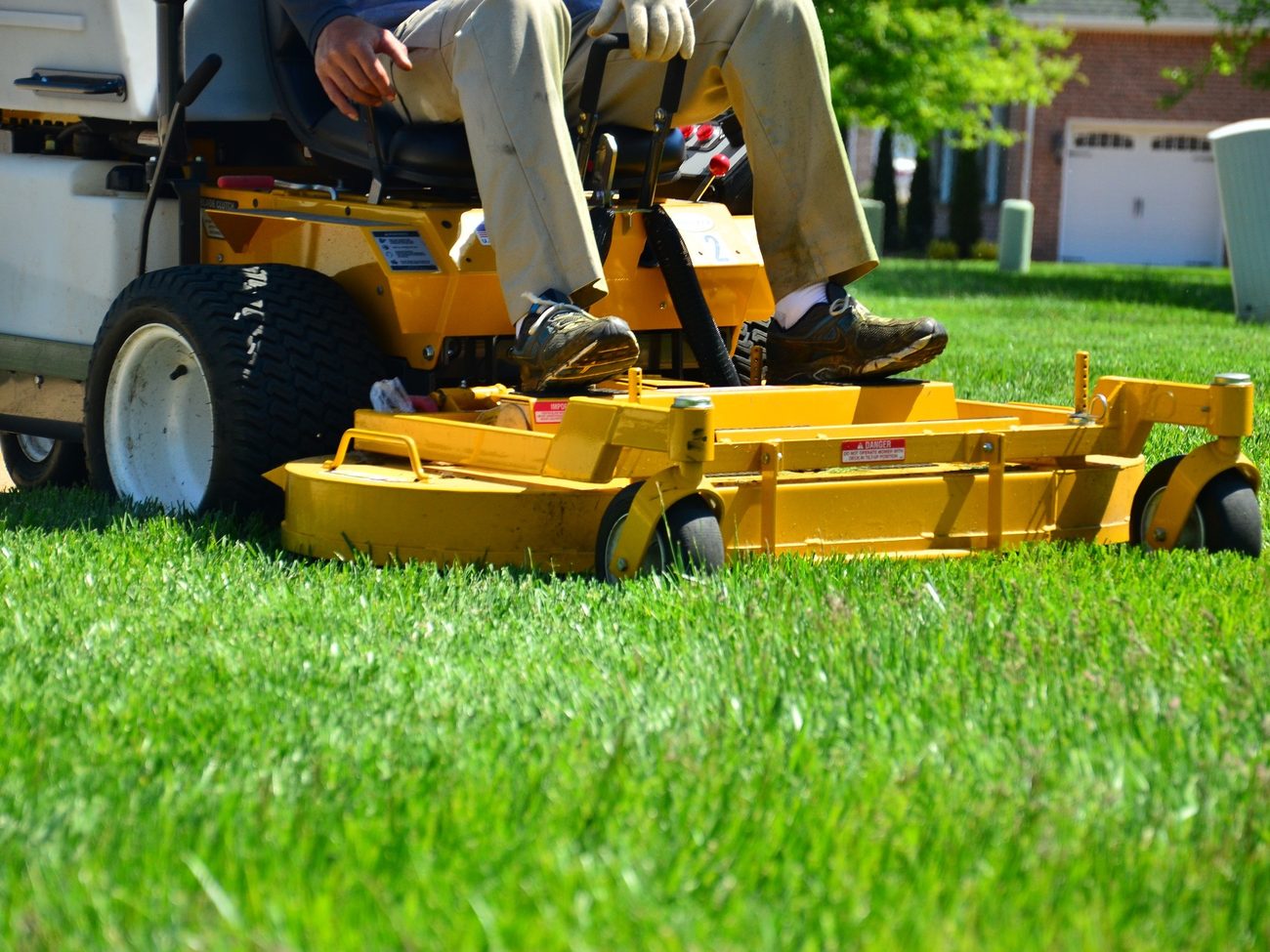 Commercial mower cutting a wide residential lawn