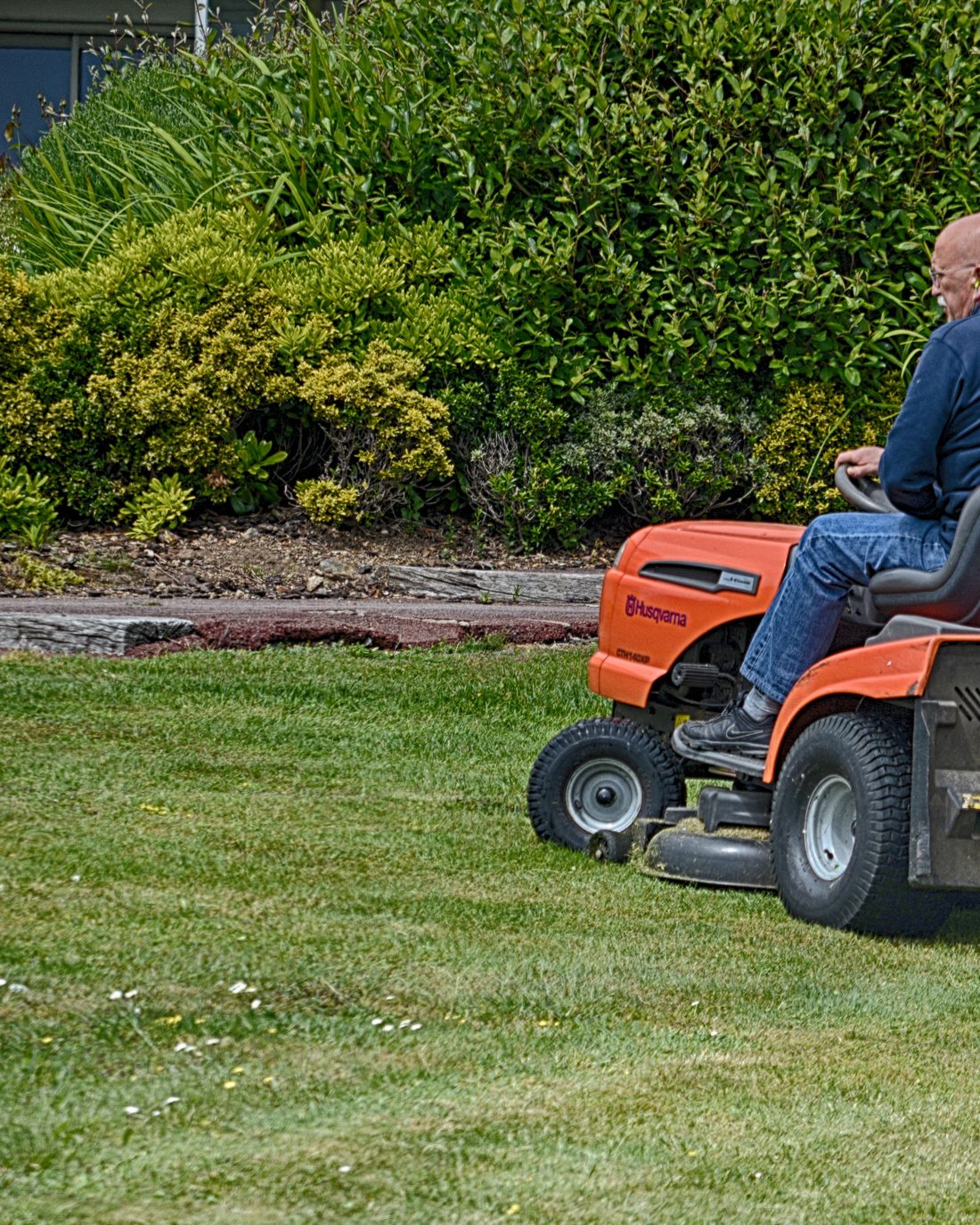 Adonai Lawns crew member mowing a residential property